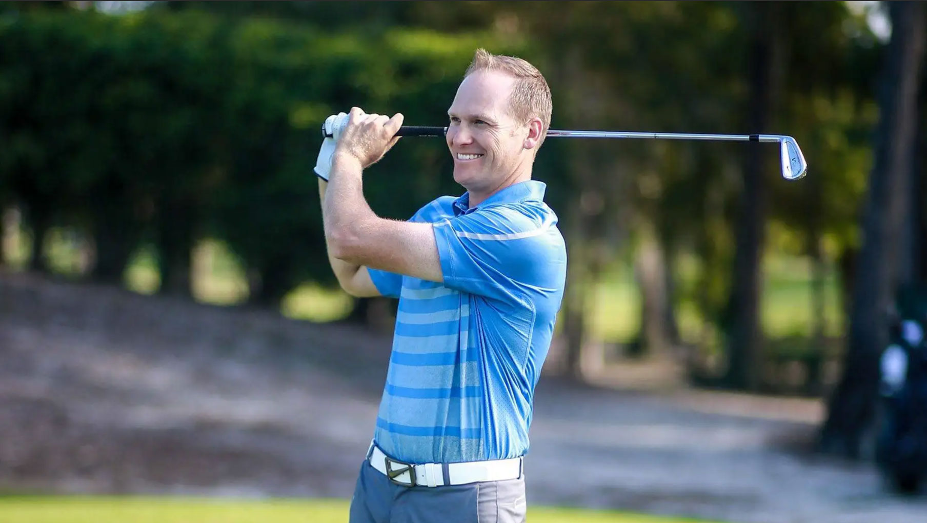 Golf instructor mid-swing at CAVU Golf Club